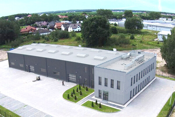 Produktionsgebäude mit Parkplatz und Grünflächen
