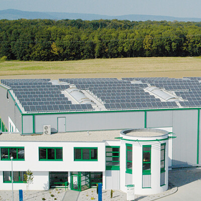 runder Büroeingangsbereich für Produktionshalle und Dach mit Photovoltaikmodulen